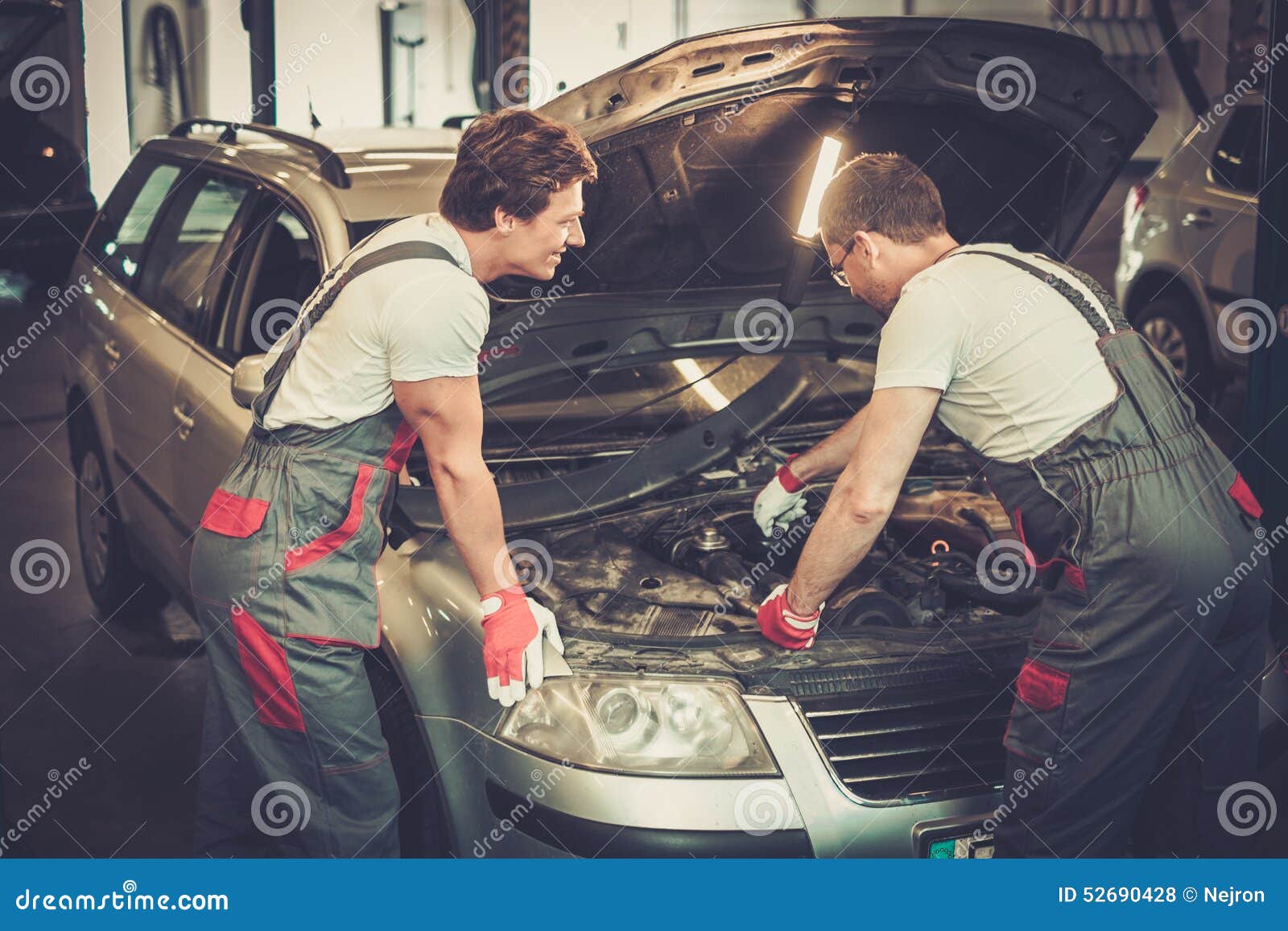 Ремонтирование машин. Механик в мастерской. Машина в ремонте в мастерской. Чинит авто в гараже.