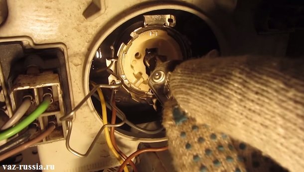 Извлечение лампы за её цоколь из фары